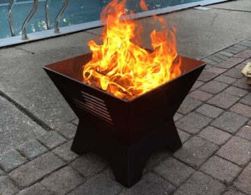 Modern Cube Fire Pit on pool deck, fire burning.