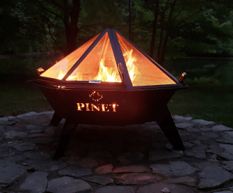 Large custom pinet fire pit burning at night.