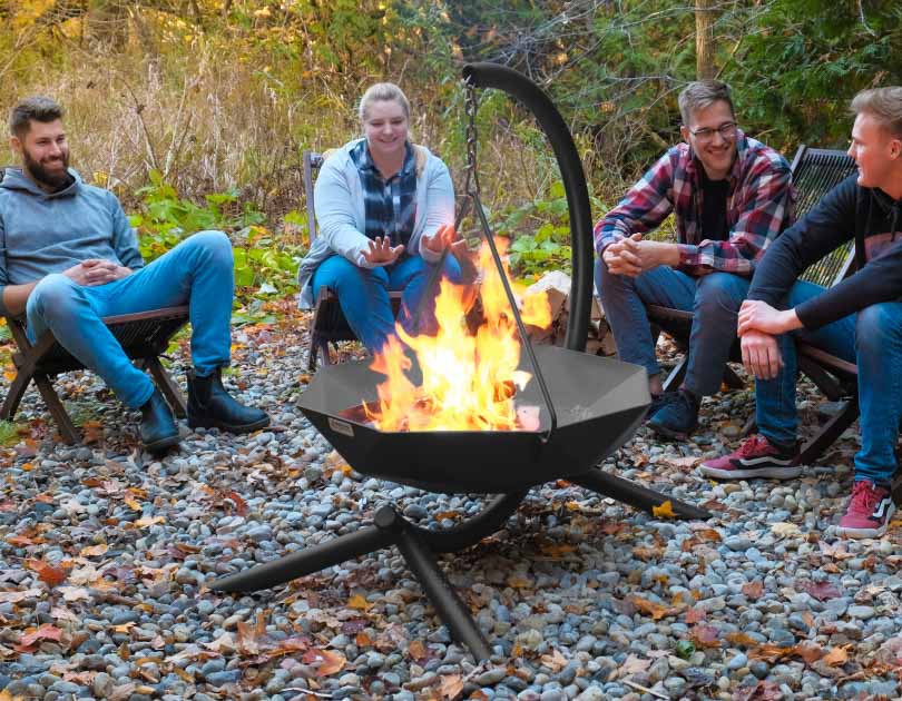 A group of friends gathered around a pendant hanging fire bowl.