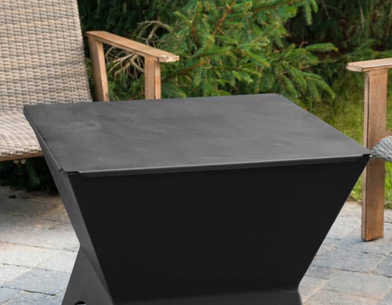 Fire pit turned table with steel lid accessory on a patio with chairs