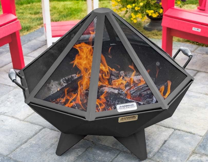 Enclosed fire in fire pit with spark screen on a patio with Adirondack chairs