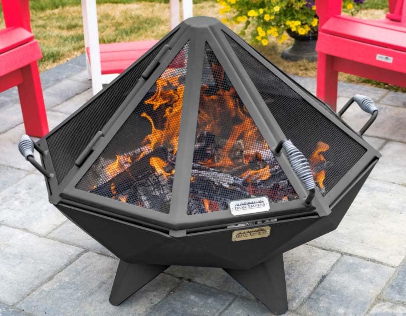 Burning fire pit with a spark screen that has a large access door for tending the coals