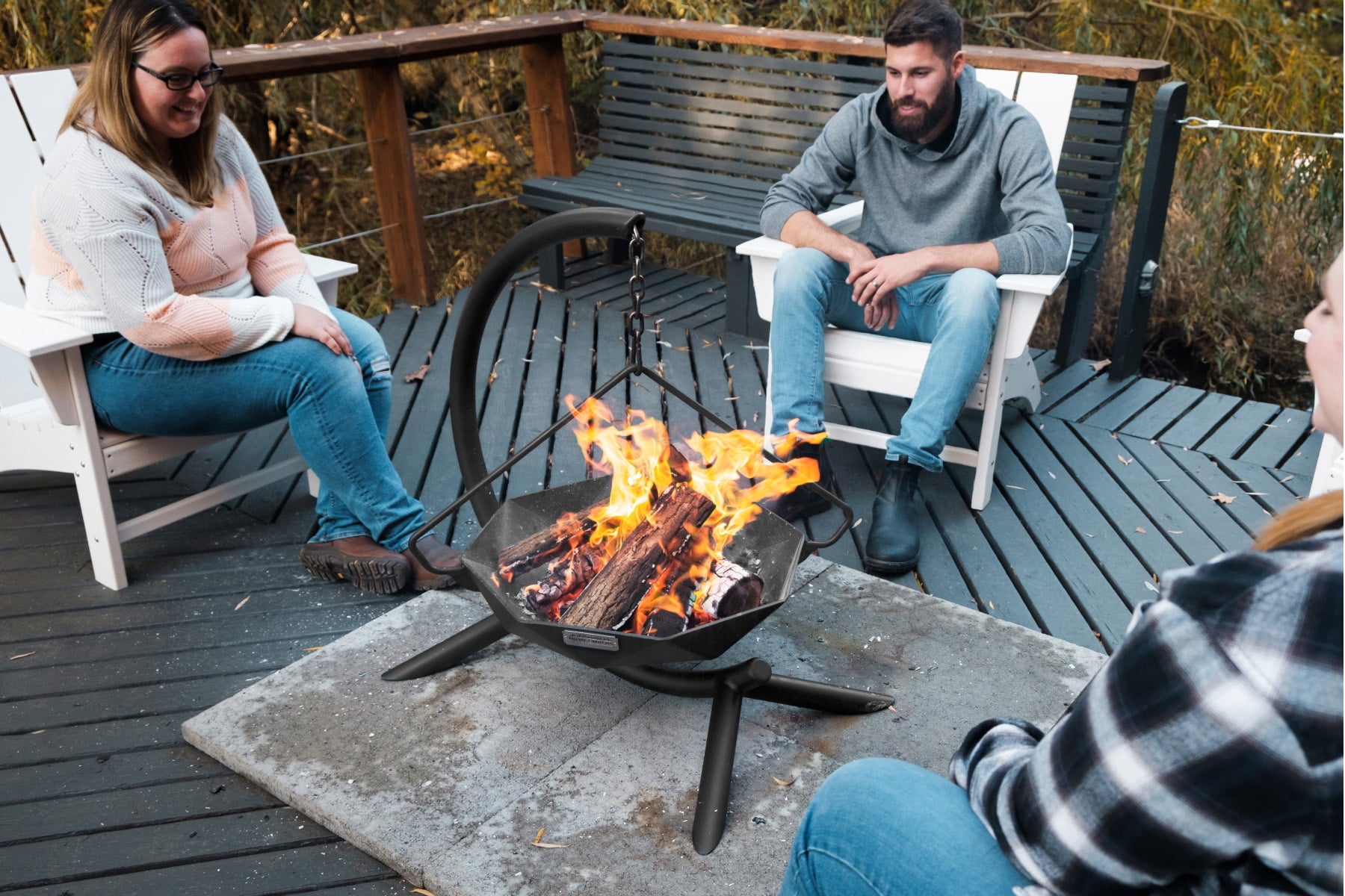 People using hanging fire pit on wood deck