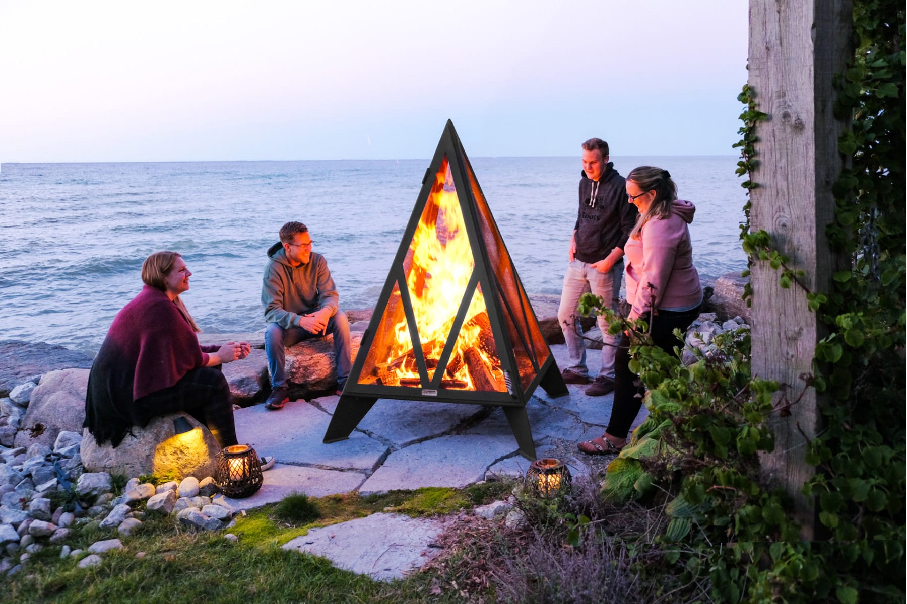 People gathered around large pyramid fire pit