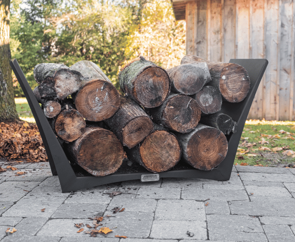 Large logs in an Iron Embers Tamarack Log holder on a stone patio