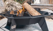 Small cottager fire pit loaded with wood on a patio