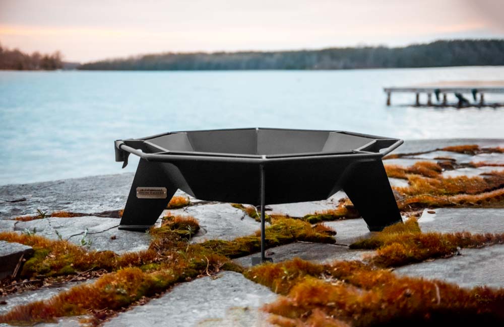 A small outdoor fire pit near the water